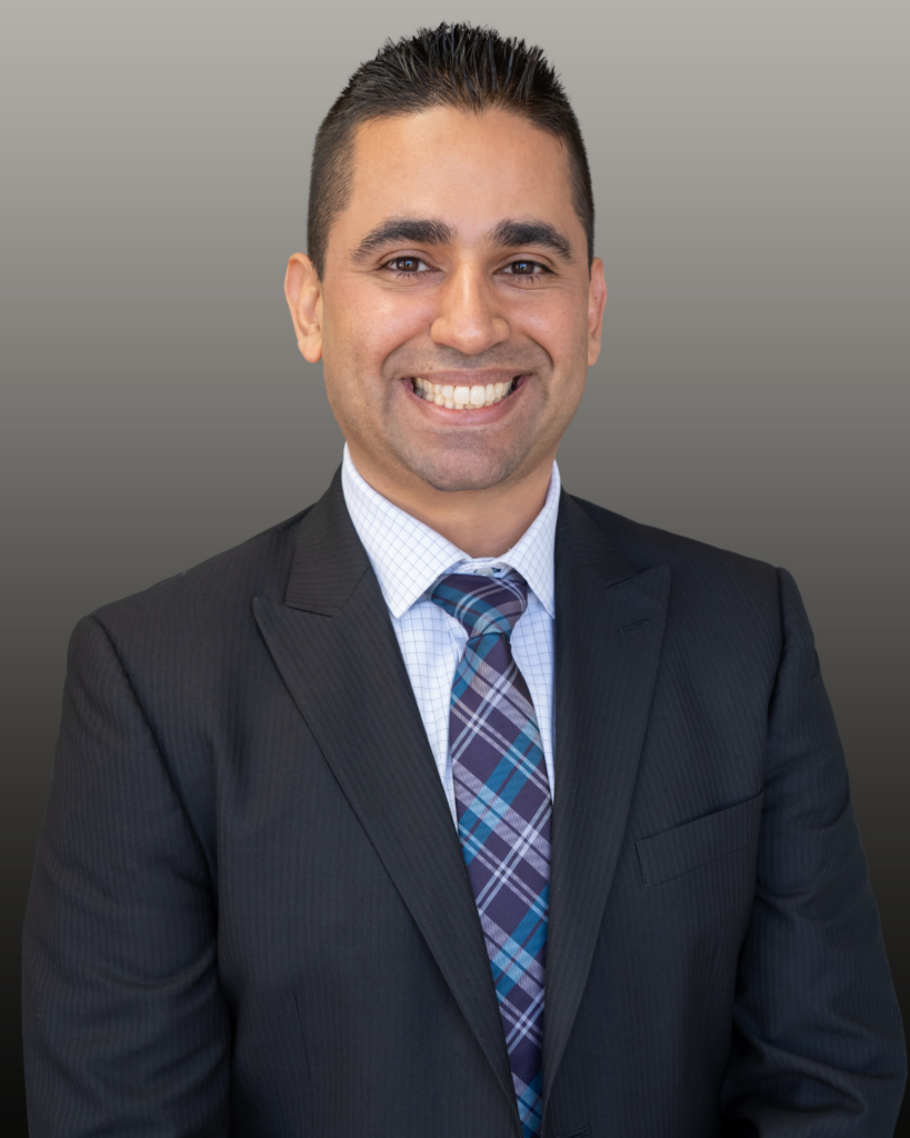 Professional headshot of smiling man in suit
