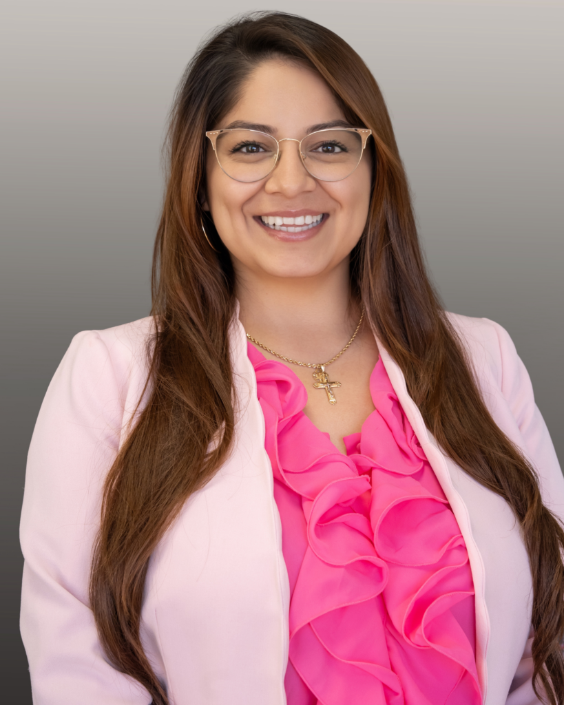 Smiling woman in pink blazer and ruffled blouse