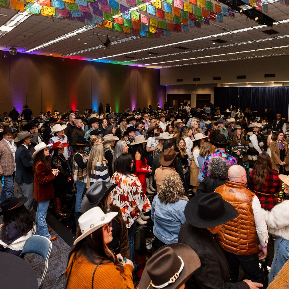 Crowd wearing cowboy hats at indoor festival