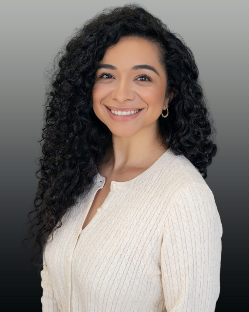 Smiling woman in white sweater, curly hair