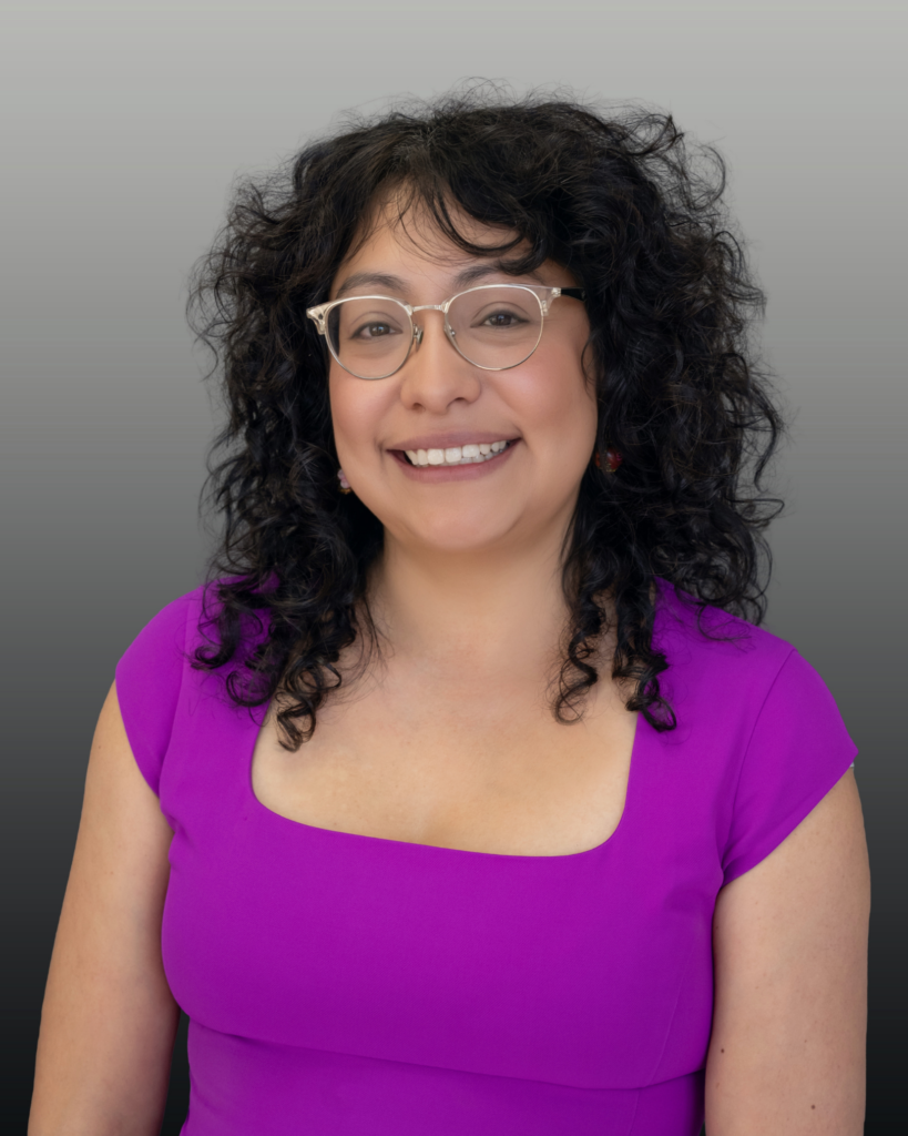 Smiling woman with glasses wearing purple dress