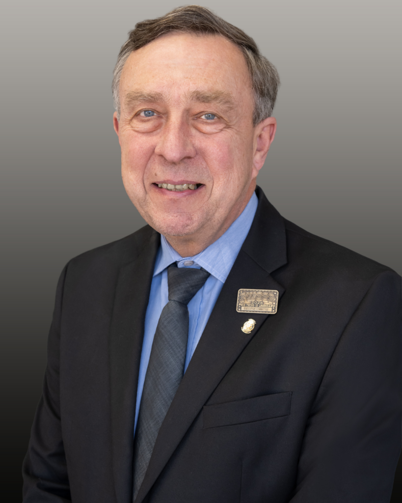 Smiling man in suit with lapel pins