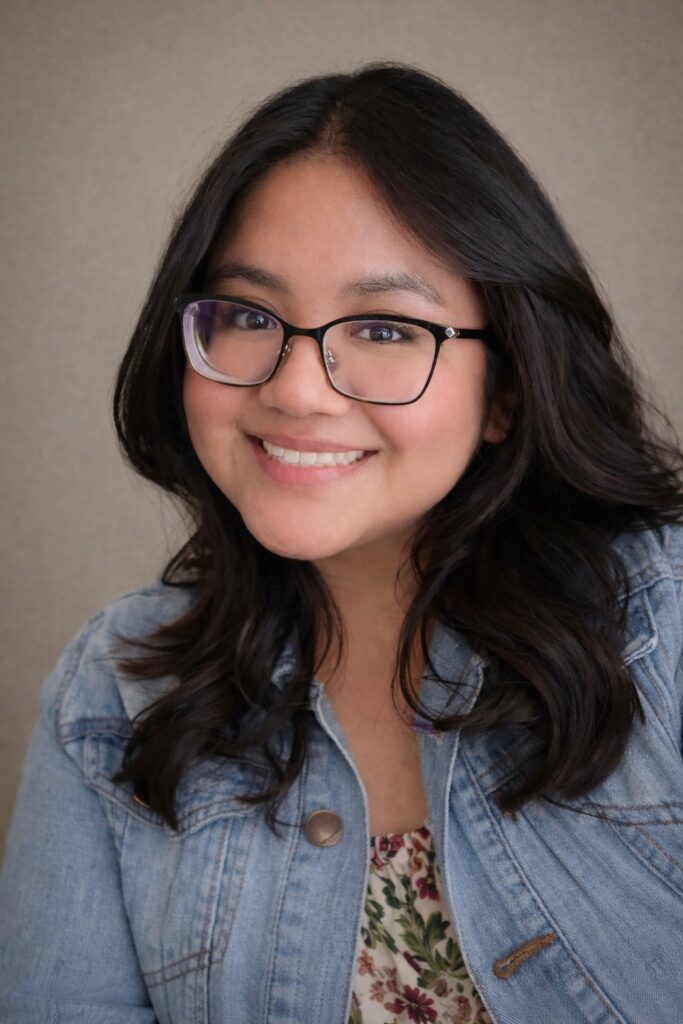 Smiling woman with glasses and denim jacket