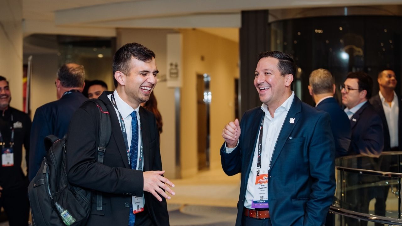 Two businessmen laughing at conference networking event