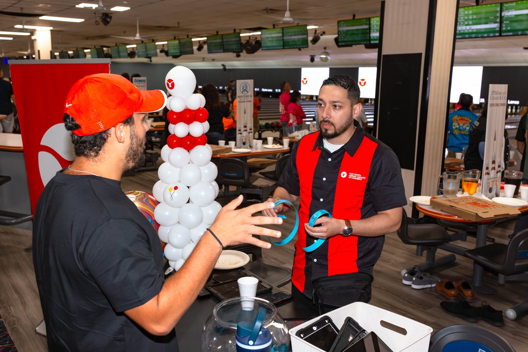 Bowling alley staff assisting customer with equipment