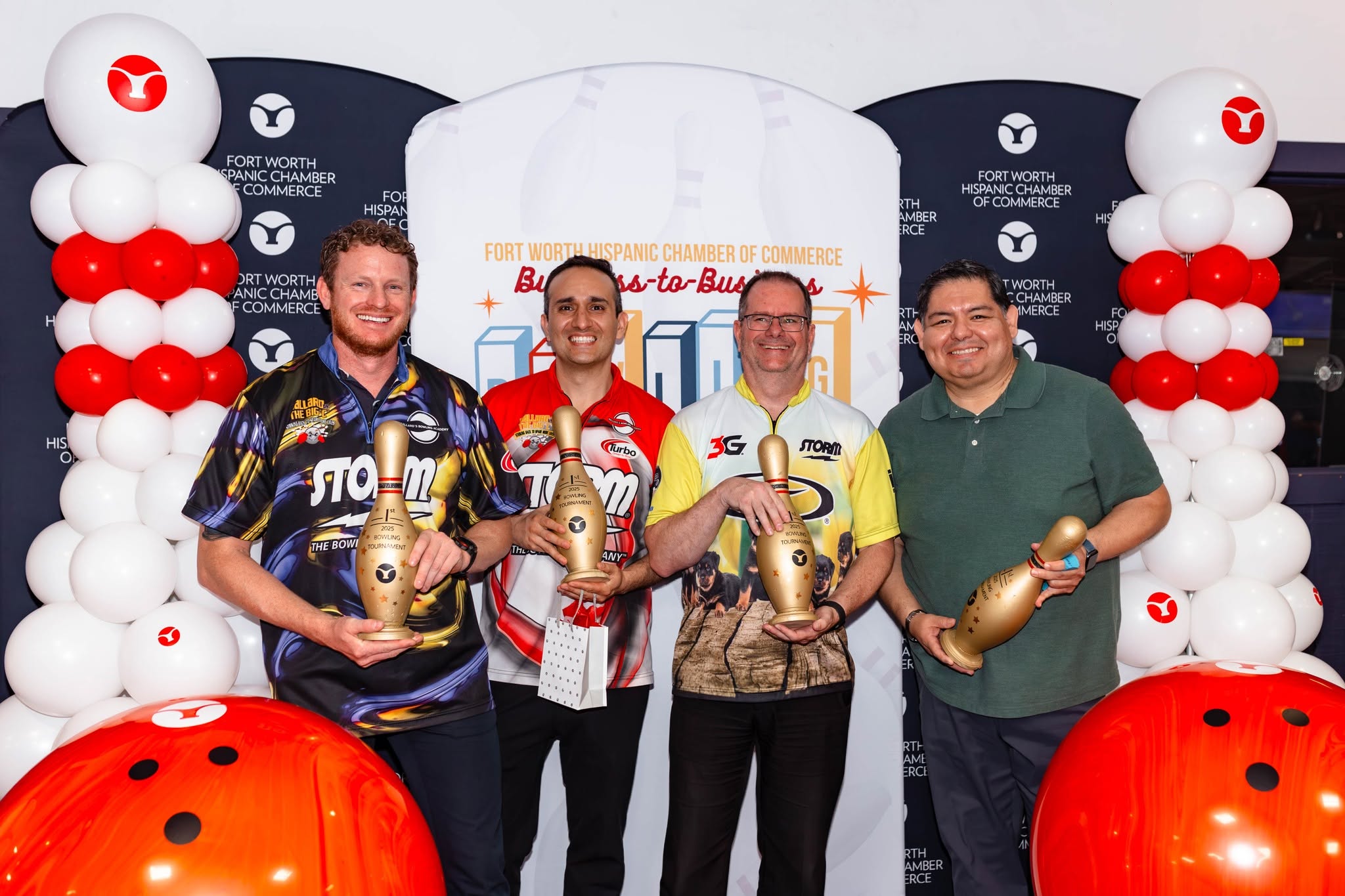 Four men holding bowling pin trophies