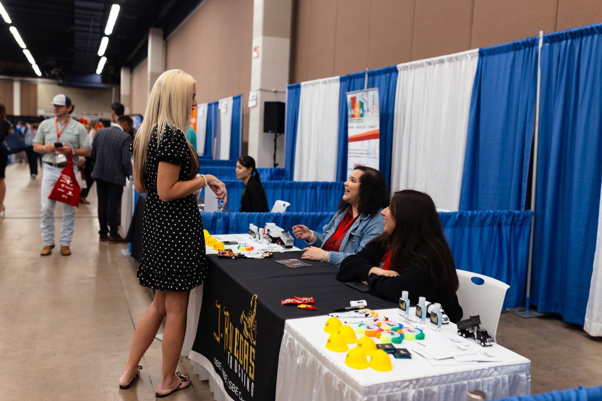 Woman talking with exhibitors at trade show booth