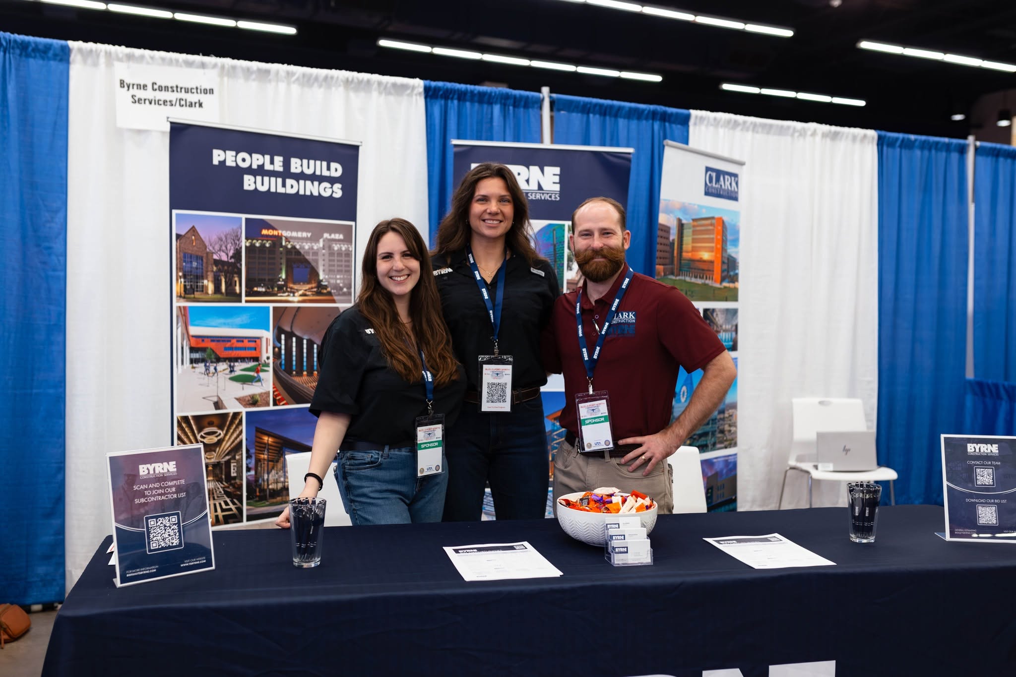 Three smiling representatives at construction trade show