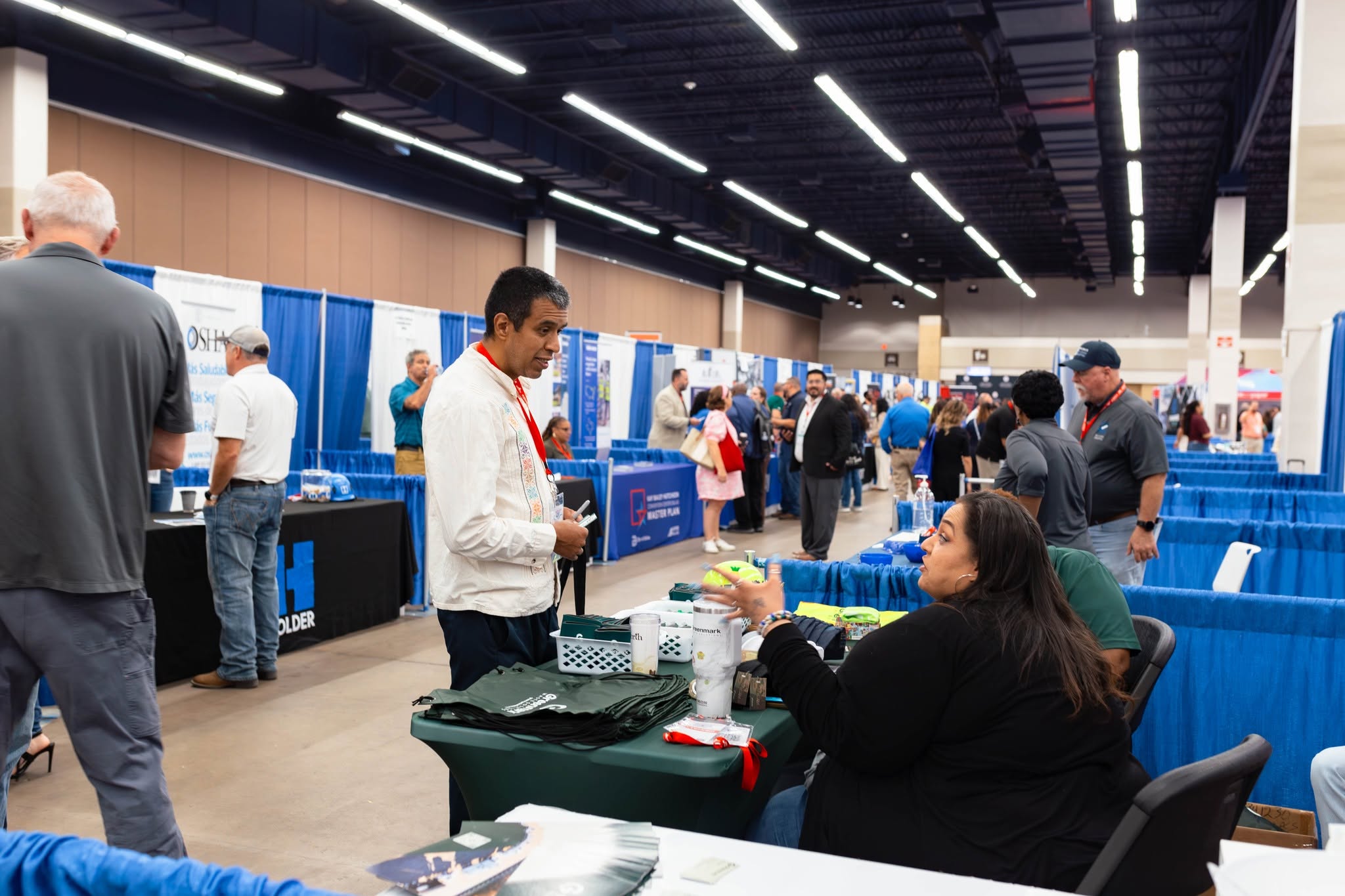 Attendees talking at busy indoor trade show