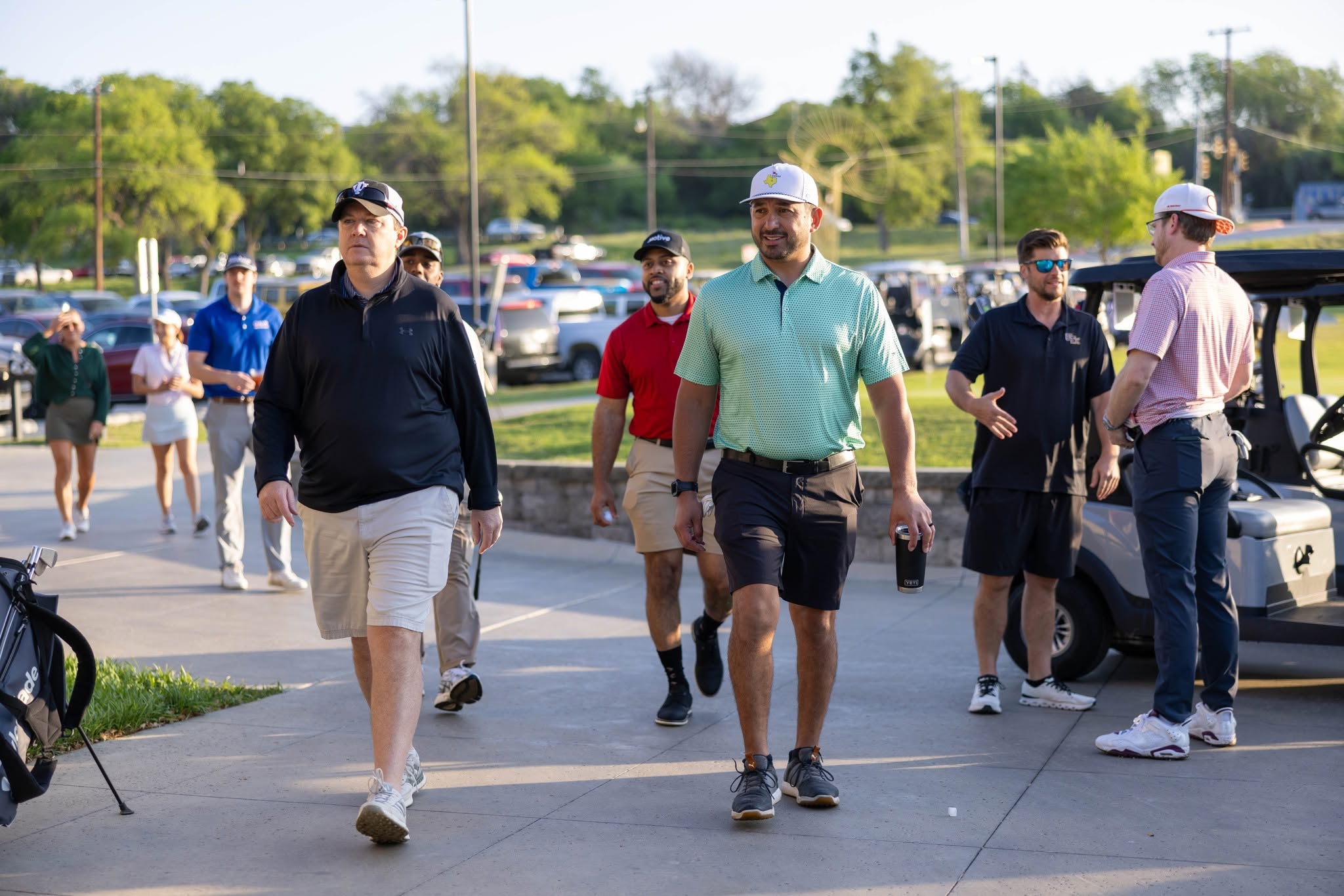Group of golfers walking near golf carts