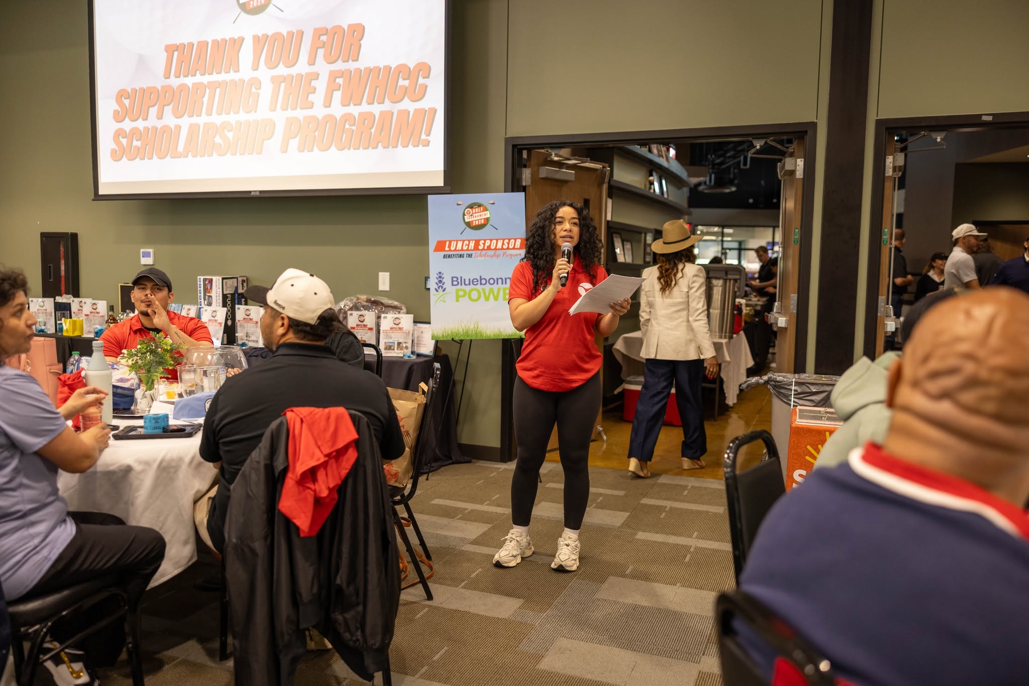 Woman speaking at indoor scholarship fundraiser event