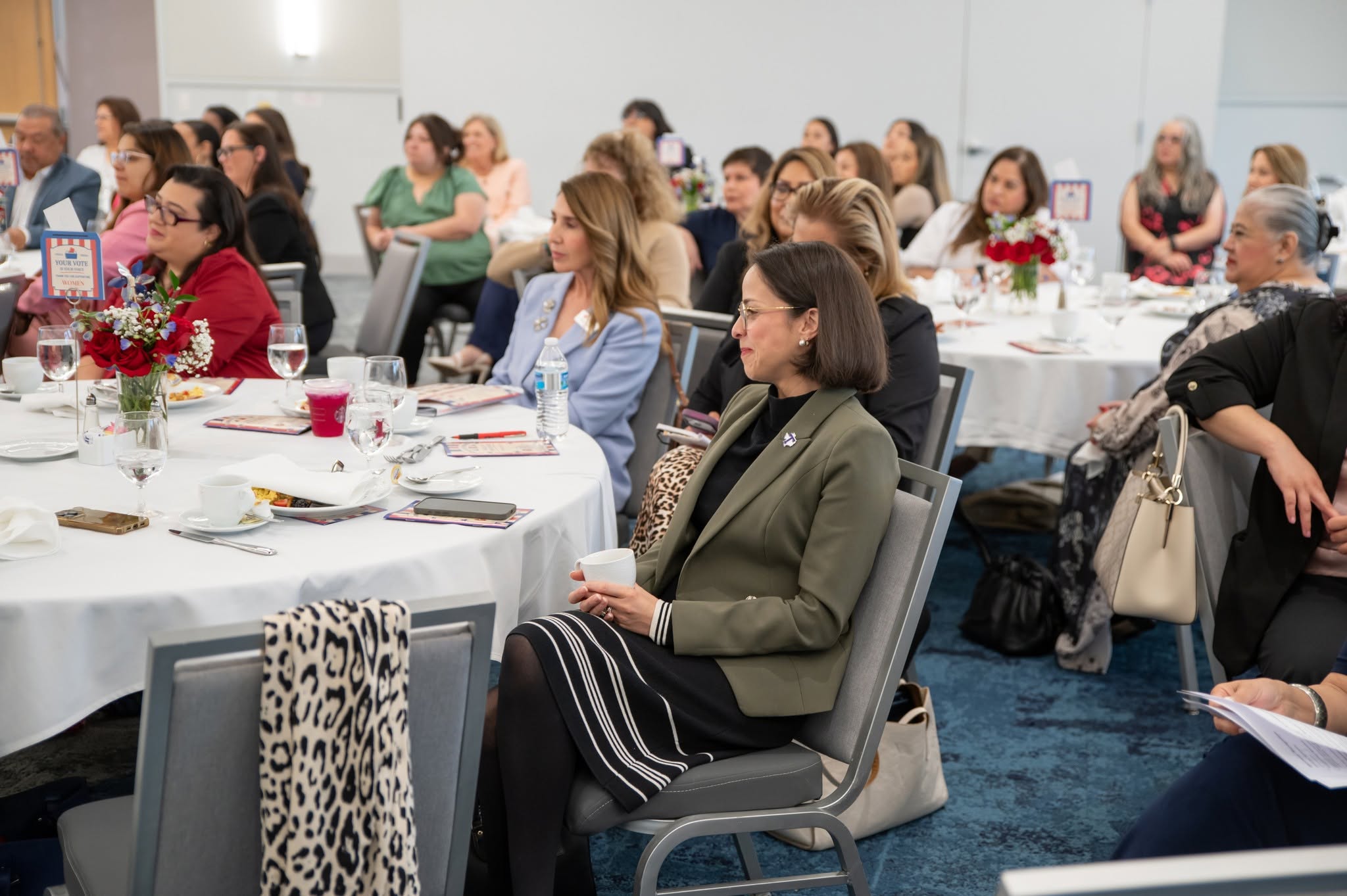Women attending conference seated at round tables