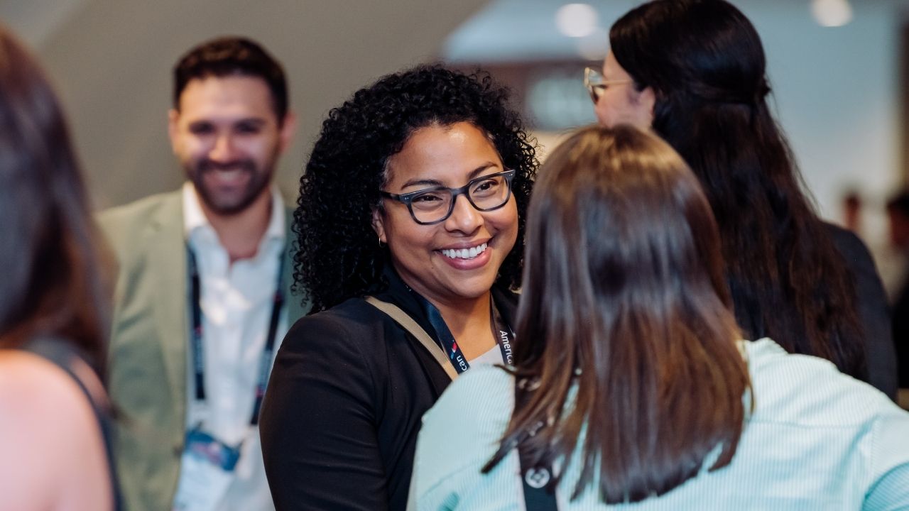 Smiling woman talking with colleagues at conference