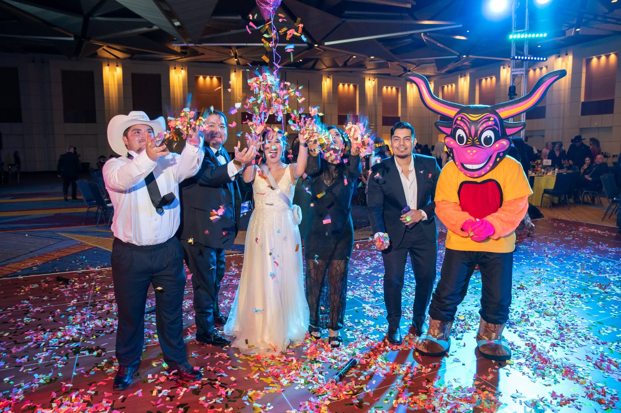 Bride, groom and guests celebrating with confetti