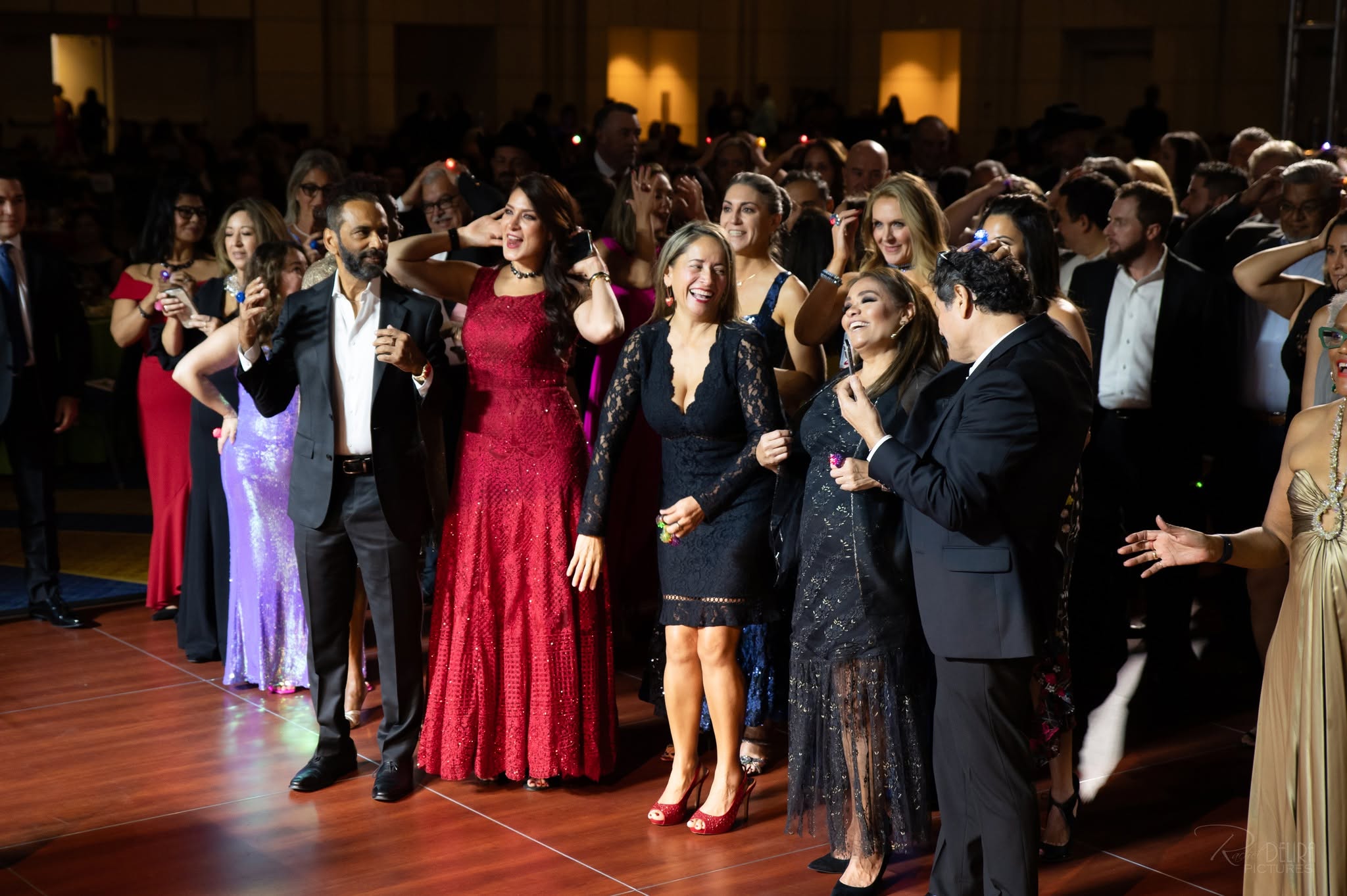 Crowd of elegantly dressed guests dancing at gala